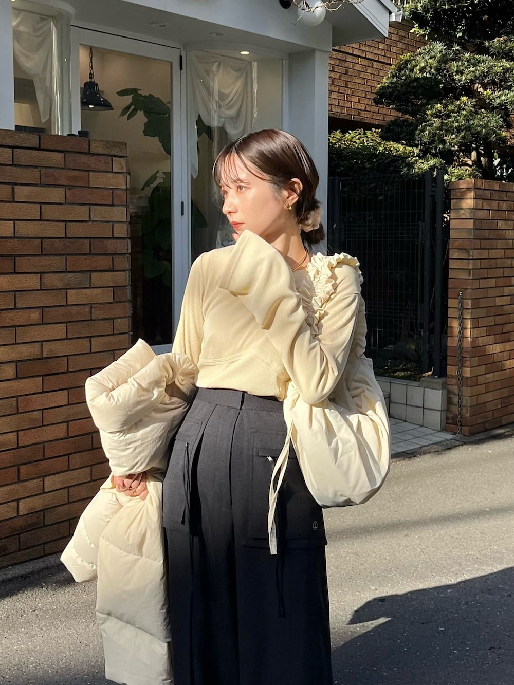 ブラック系のその他パンツ、ブラック系のパンプス、ベージュ系のTシャツ/カットソーを着用したレディースの冬コーディネートの3枚目の写真