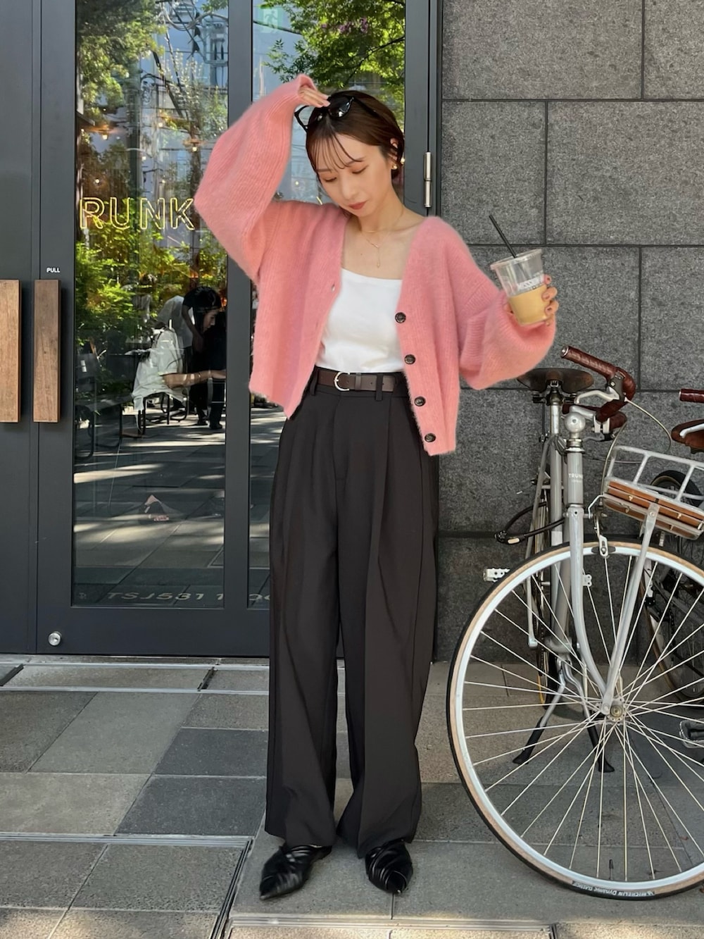 ブラック系のスラックス、ピンク系のカーディガン/ボレロ、ホワイト系のタンクトップを着用したレディースの夏コーディネートの2枚目の写真