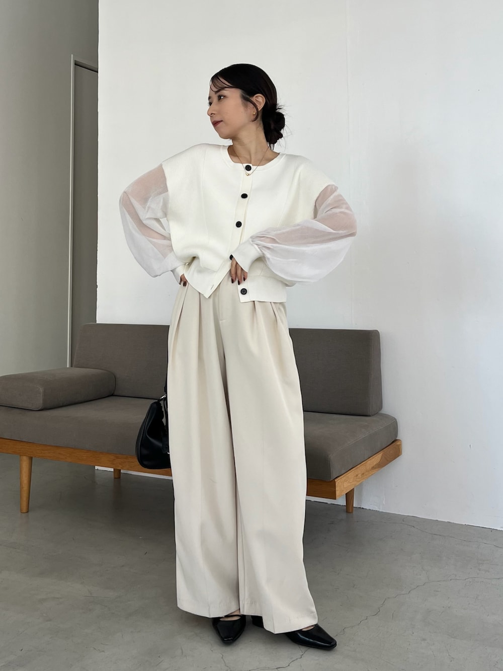 ホワイト系のニット/セーター、ホワイト系のその他パンツ、ブラック系のショルダーバッグを着用したレディースの冬コーディネートの4枚目の写真