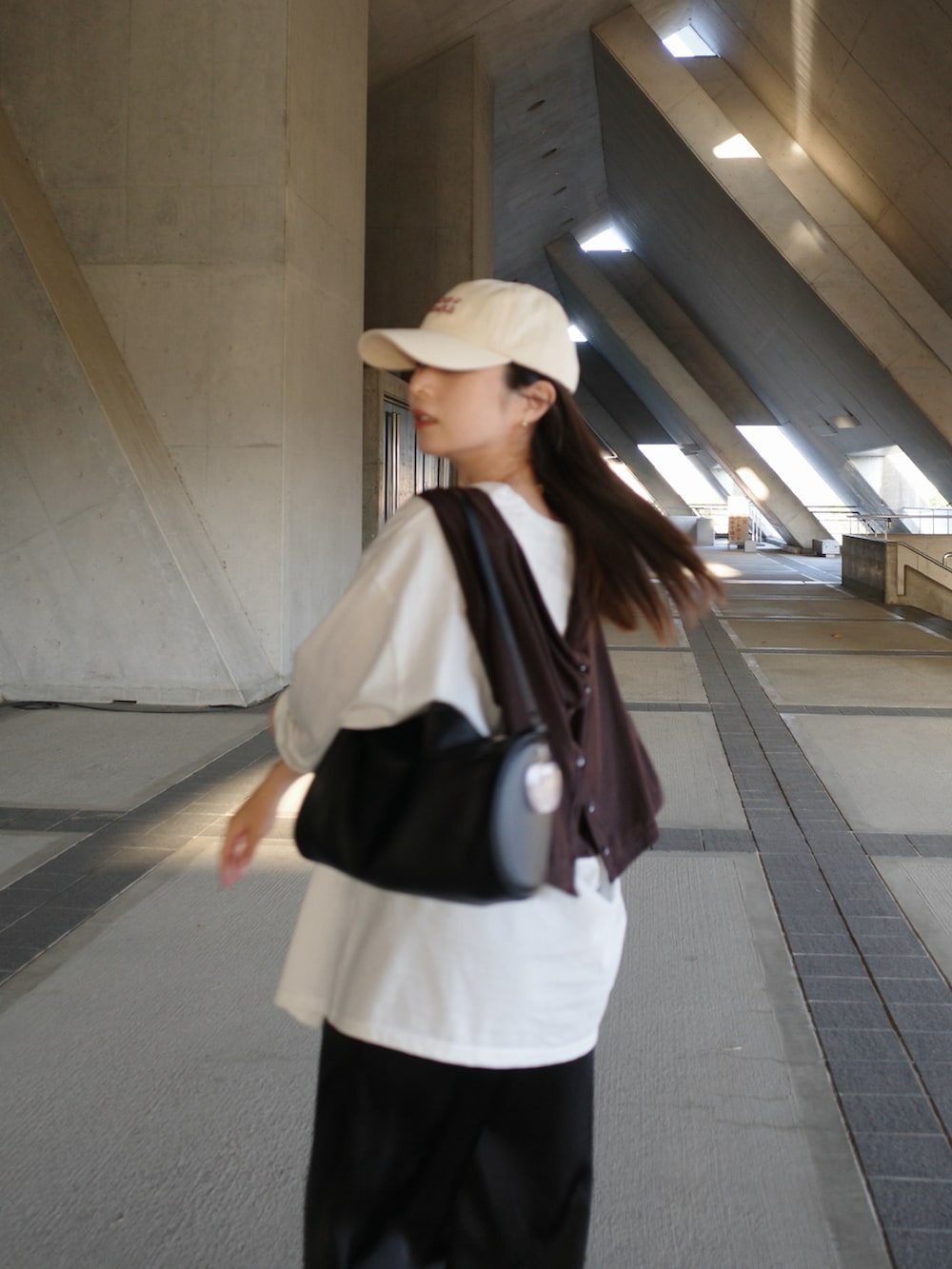 ブラック系のハンドバッグ、ブラック系のその他パンツ、ホワイト系のTシャツ/カットソーを着用したレディースの春コーディネートの3枚目の写真