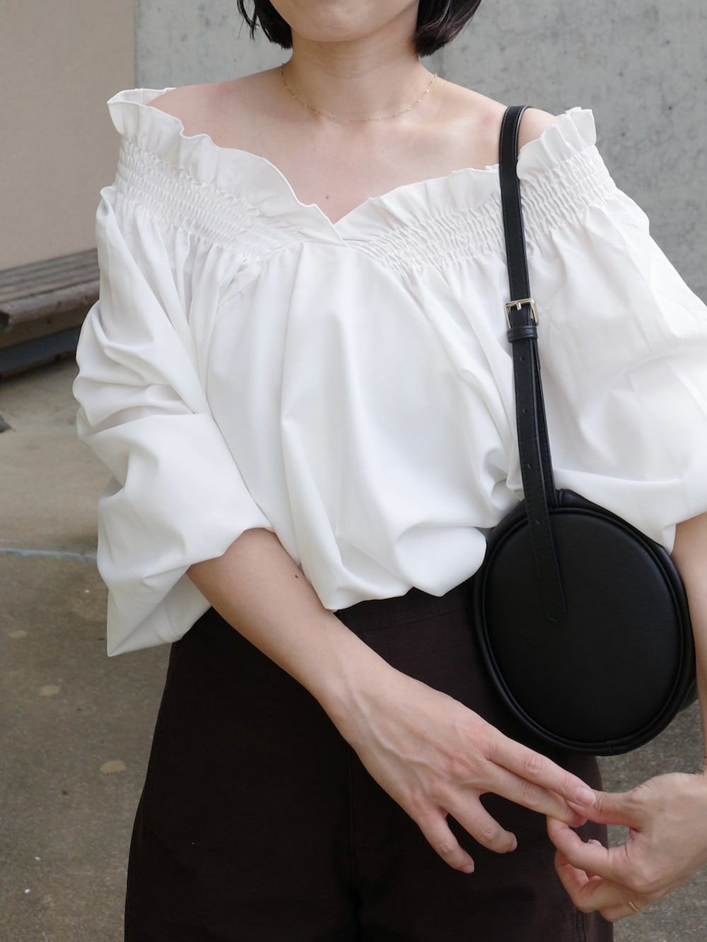 ブラウン系のパンツ、ホワイト系のシャツ/ブラウス、ブラック系のハンドバッグを着用したレディースの秋コーディネートの3枚目の写真