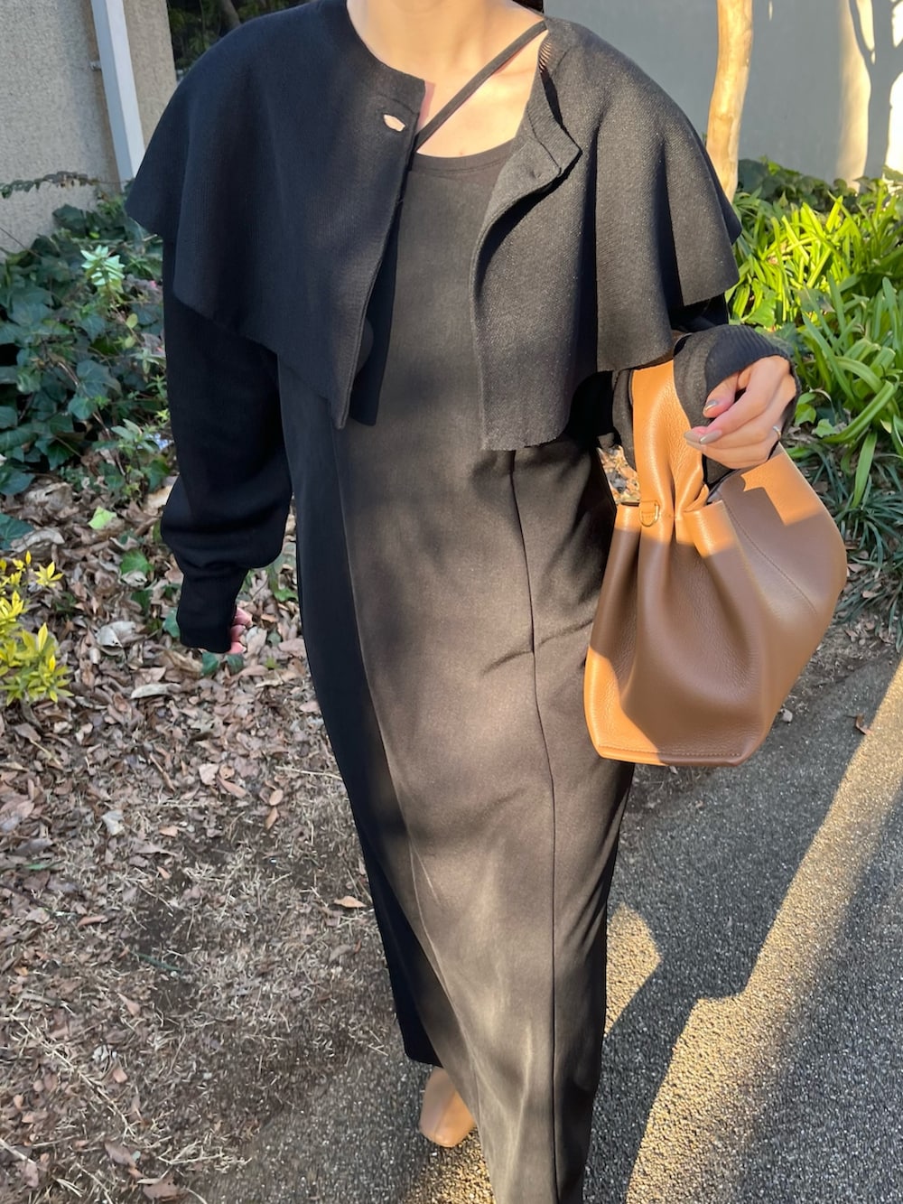 ブラック系のワンピース、ブラウン系のバッグ、ホワイト系のその他を着用したレディースの冬コーディネートの4枚目の写真