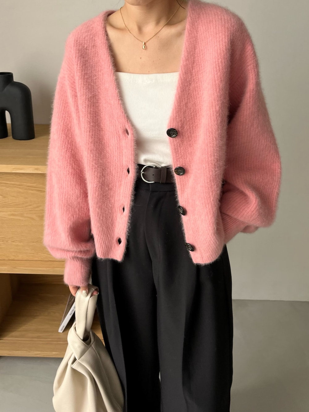 ブラック系のスラックス、ピンク系のカーディガン/ボレロ、ホワイト系のタンクトップを着用したレディースの夏コーディネートの6枚目の写真