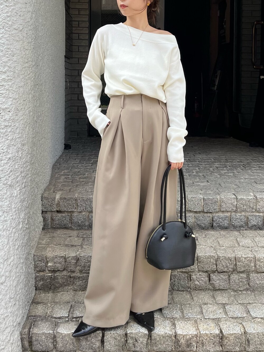 ベージュ系のその他パンツ、ホワイト系のニット/セーター、ブラック系のパンプスを着用したレディースの秋コーディネートの2枚目の写真