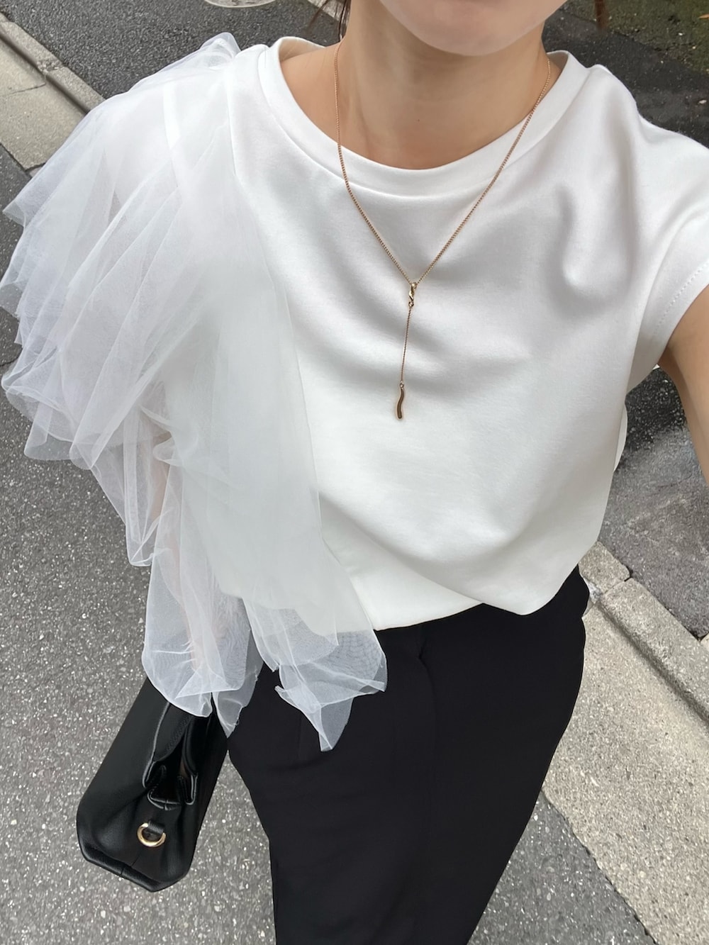 ブラック系のスカート、ホワイト系のTシャツ/カットソー、ブラック系のショルダーバッグを着用したレディースの夏コーディネートの5枚目の写真