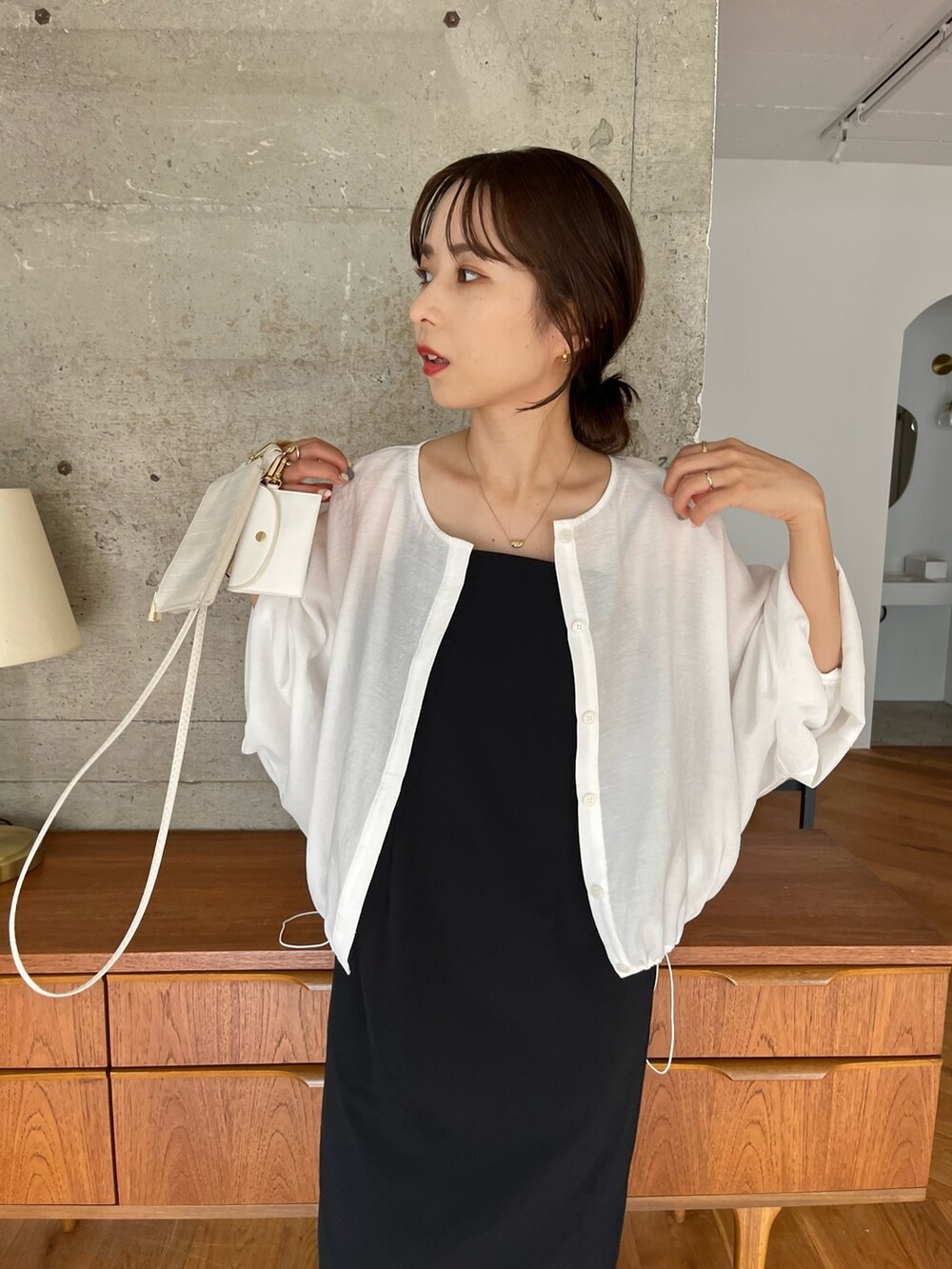 ブラック系のワンピース、ホワイト系のブルゾン、ブラック系のトートバッグを着用したレディースの夏コーディネートの4枚目の写真