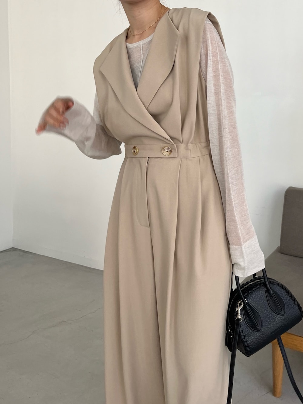 ブラック系のパンプス、ホワイト系のニット/セーター、ベージュ系のつなぎ/オールインワンを着用したレディースの冬コーディネートの5枚目の写真