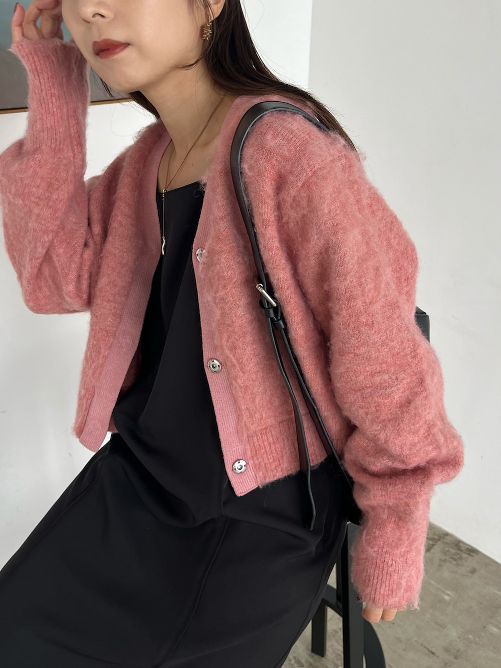 ブラック系のワンピース、ブラック系のパンプス、ブラック系のショルダーバッグを着用したレディースの秋コーディネートの6枚目の写真