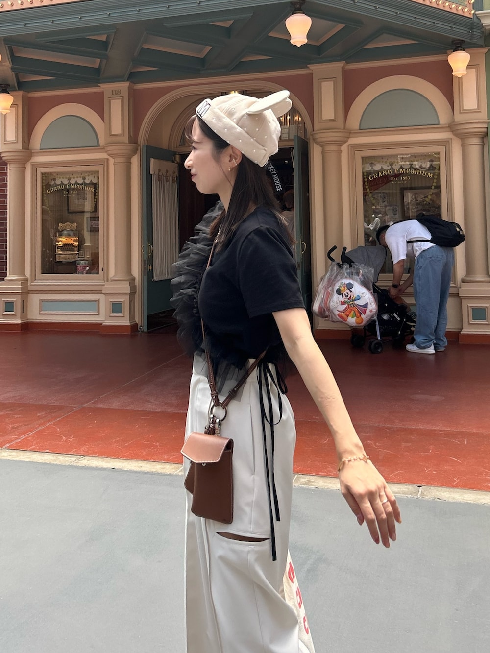 ホワイト系のその他パンツ、ブラック系のTシャツ/カットソー、ブラウン系のショルダーバッグを着用したレディースの夏コーディネートの3枚目の写真