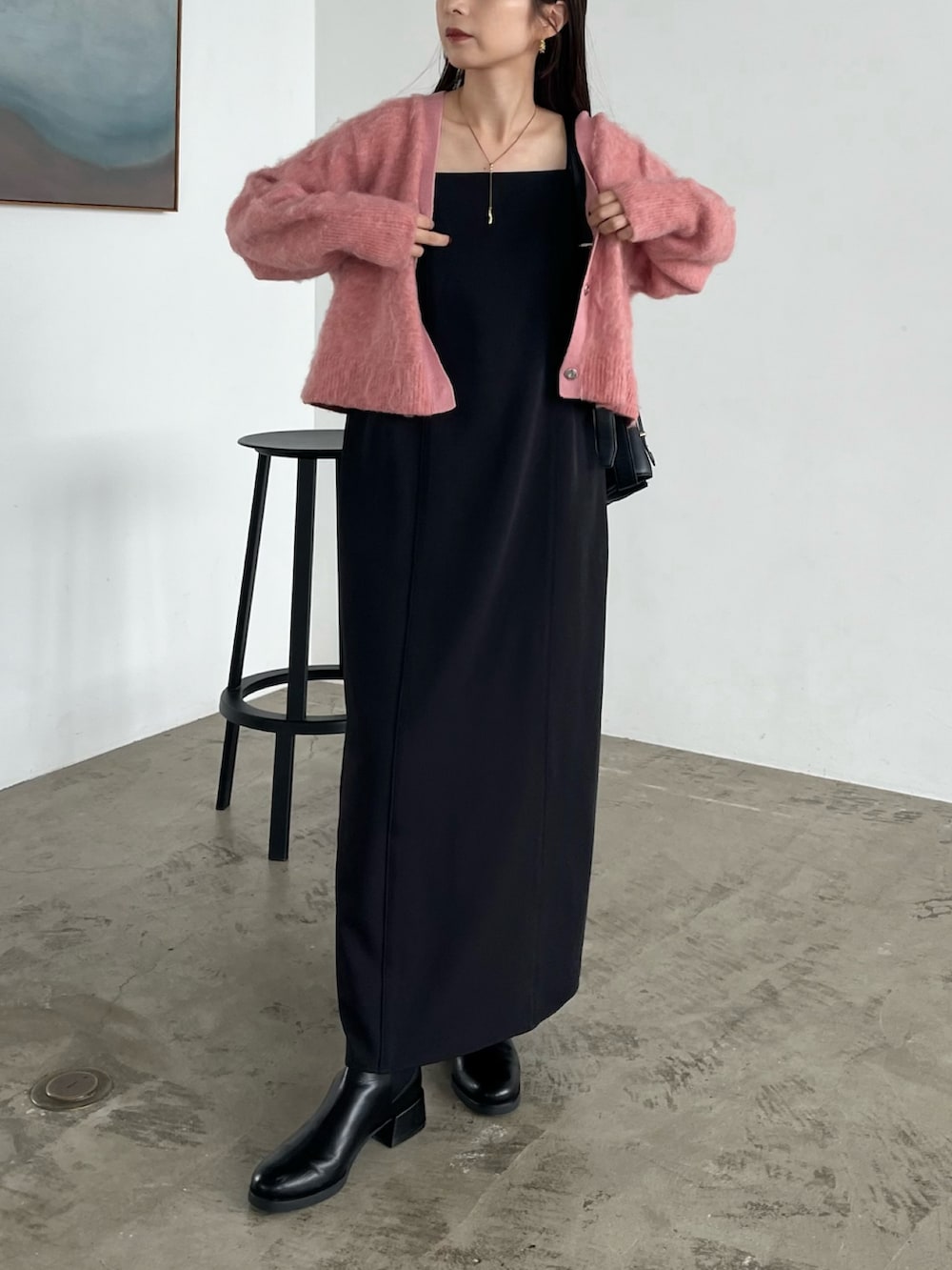 ブラック系のワンピース、ブラック系のパンプス、ブラック系のショルダーバッグを着用したレディースの秋コーディネートの2枚目の写真