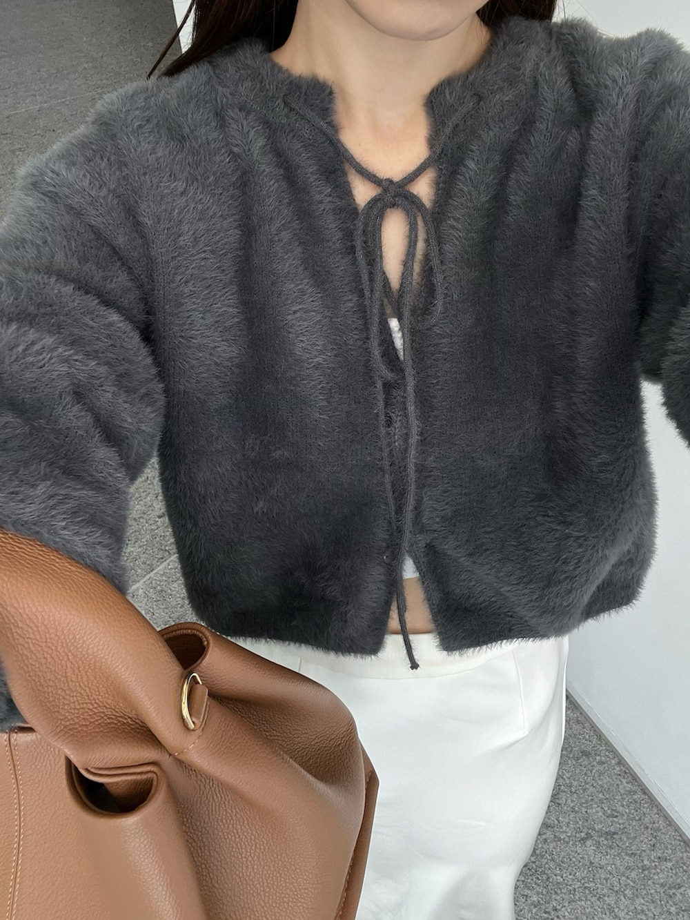 ホワイト系のスカート、ブラウン系のバッグ、グレー系のカーディガン/ボレロを着用したレディースの秋コーディネートの5枚目の写真