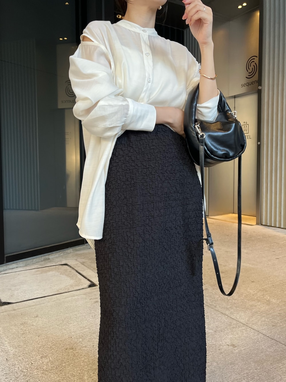 ブラック系のサンダル、ホワイト系のシャツ/ブラウス、ブラック系のスカートを着用したレディースの夏コーディネートの3枚目の写真