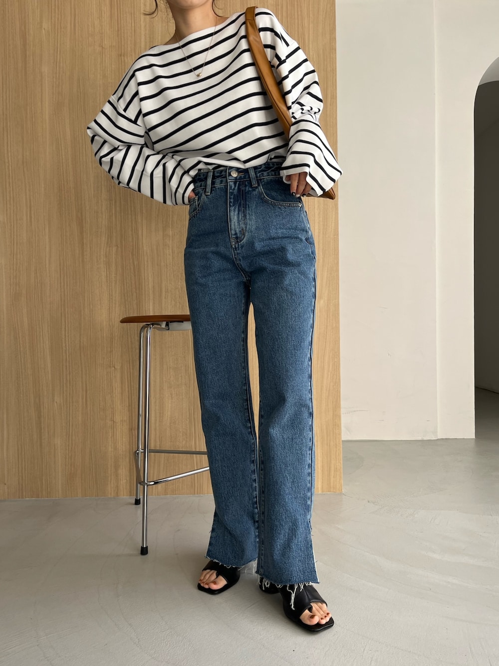 ホワイト系のニット/セーター、ブルー系のデニムパンツ、ブラック系のサンダルを着用したレディースの冬コーディネートの6枚目の写真