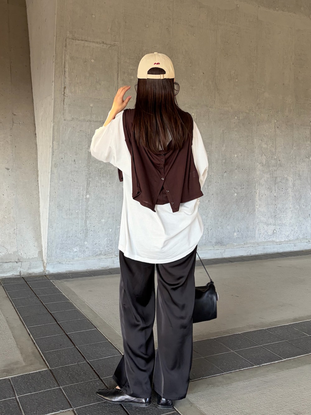 ブラック系のハンドバッグ、ブラック系のその他パンツ、ホワイト系のTシャツ/カットソーを着用したレディースの春コーディネートの2枚目の写真