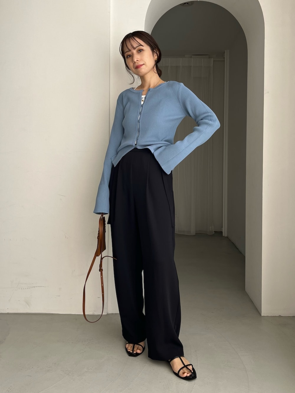 ブラック系のその他パンツ、ブルー系のカーディガン/ボレロ、ブラウン系のトートバッグを着用したレディースの冬コーディネートの3枚目の写真
