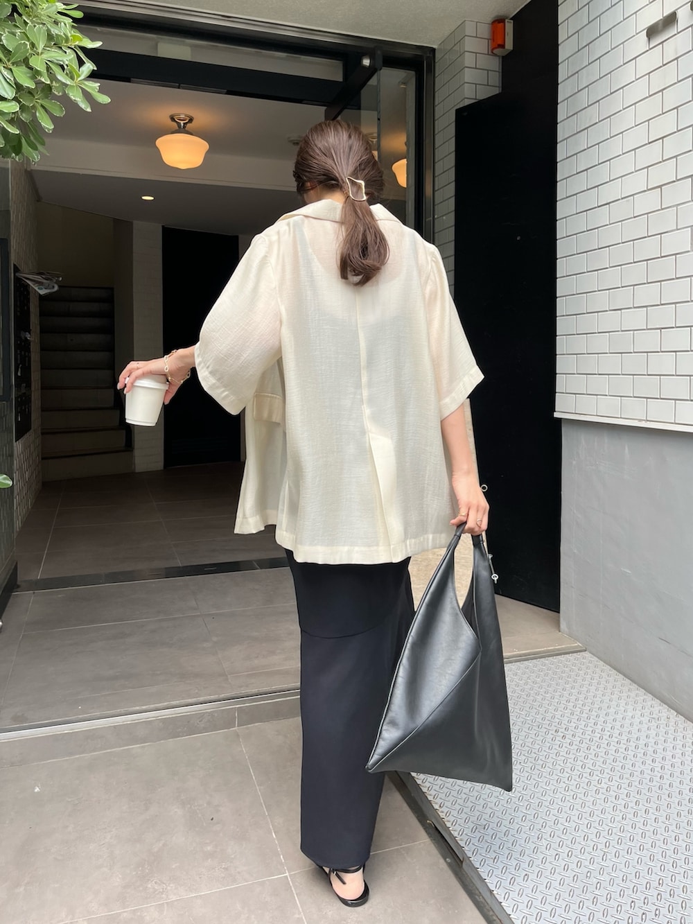 ブラック系のワンピース、ブラック系のその他シューズ、ホワイト系のテーラードジャケットを着用したレディースの春コーディネートの4枚目の写真