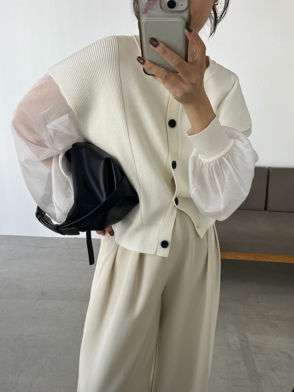 ホワイト系のニット/セーター、ホワイト系のその他パンツ、ブラック系のショルダーバッグを着用したレディースの冬コーディネートの2枚目の写真