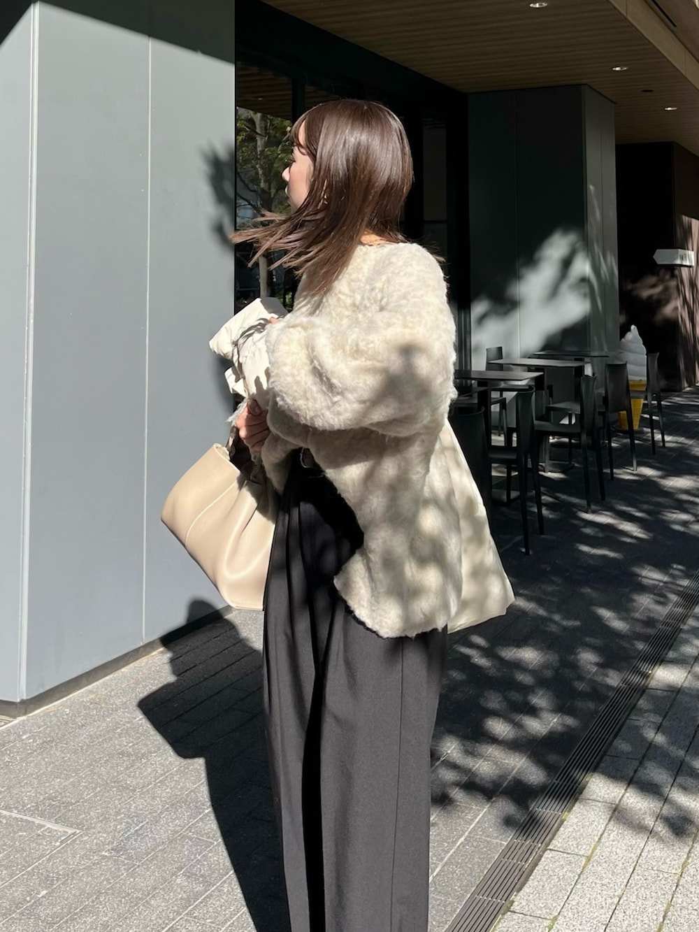 ベージュ系のニット/セーター、ブラック系のスラックス、ブラック系のブーツを着用したレディースの冬コーディネートの3枚目の写真