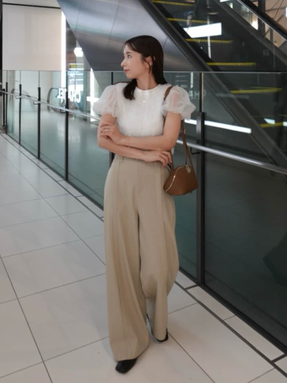 イエロー系のショルダーバッグ、ベージュ系のその他パンツ、ホワイト系のTシャツ/カットソーを着用したレディースの夏コーディネートの5枚目の写真