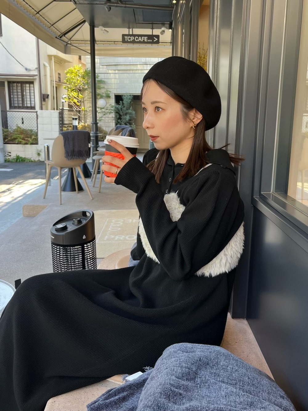 ブラック系のワンピース、ホワイト系のダウンジャケット/コート、グリーン系のトップスを着用したレディースの冬コーディネートの4枚目の写真