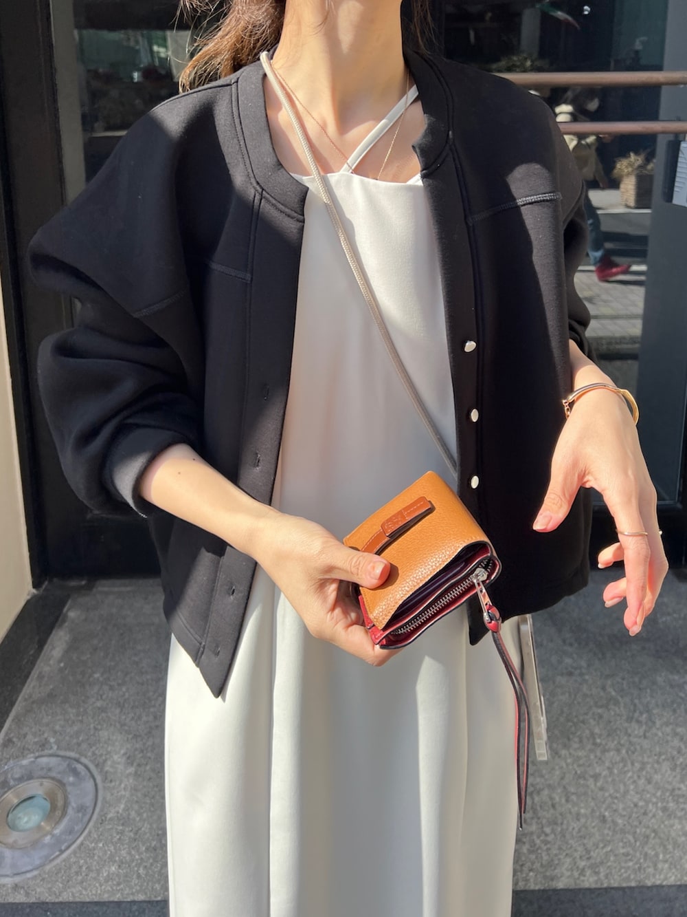 ブラック系のワンピース、ブラック系のカーディガン/ボレロ、ホワイト系のサンダルを着用したレディースの冬コーディネートの4枚目の写真