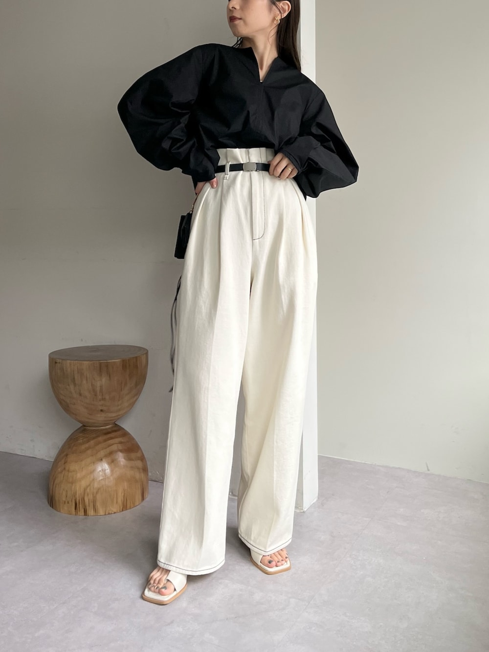 ホワイト系のデニムパンツ、ブラック系のシャツ/ブラウス、ホワイト系のシューズを着用したレディースの春コーディネートの5枚目の写真