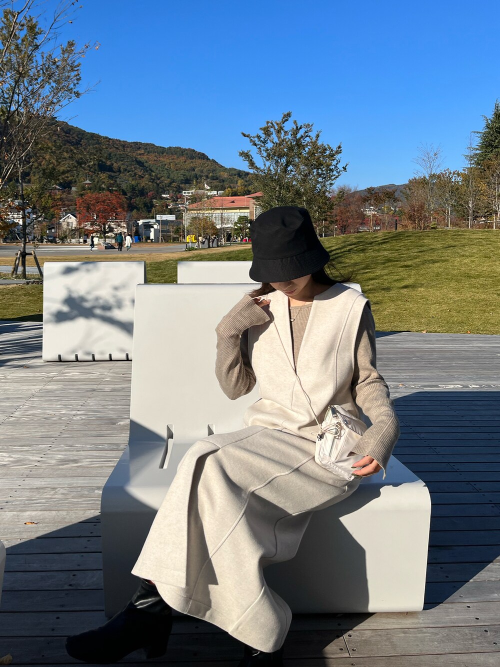 ホワイト系のワンピース、ベージュ系のニット/セーター、ホワイト系のその他を着用したレディースの冬コーディネートの3枚目の写真