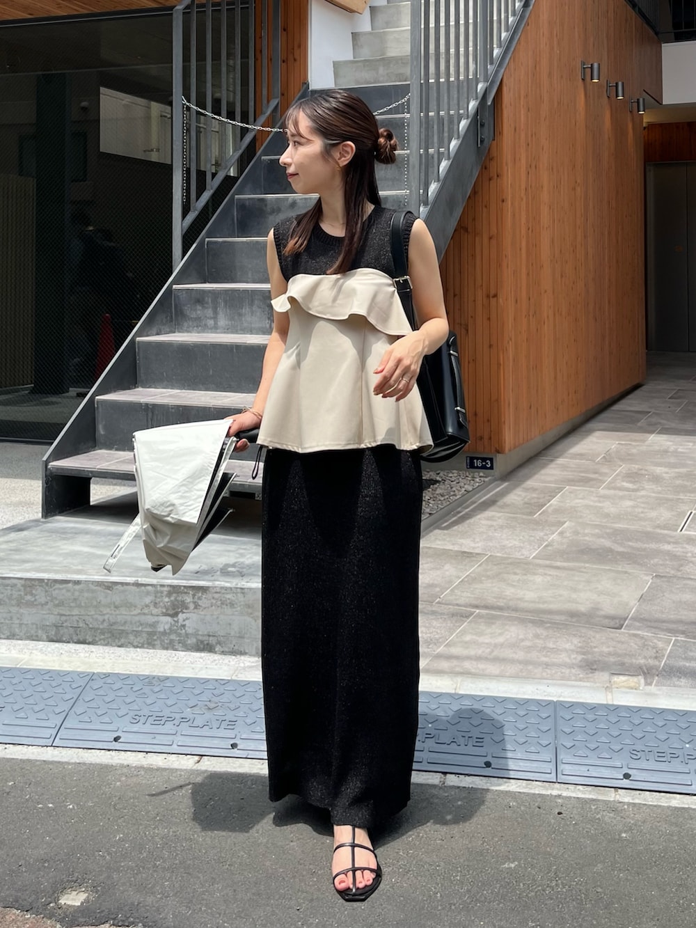 ブラック系のワンピース、ベージュ系のシャツ/ブラウス、ブラック系のショルダーバッグを着用したレディースの夏コーディネートの2枚目の写真