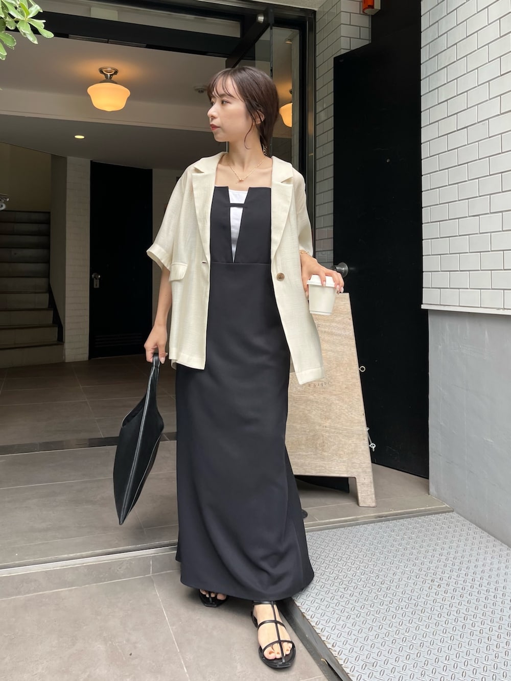 ブラック系のワンピース、ブラック系のその他シューズ、ホワイト系のテーラードジャケットを着用したレディースの春コーディネートの3枚目の写真