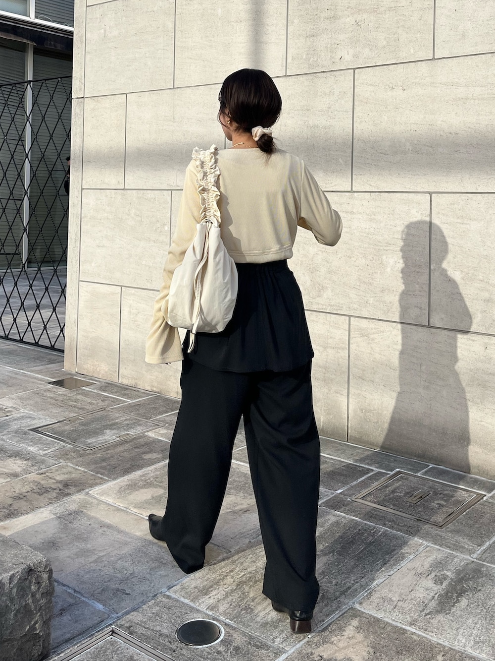 ブラック系のその他パンツ、ブラック系のパンプス、ベージュ系のTシャツ/カットソーを着用したレディースの冬コーディネートの5枚目の写真