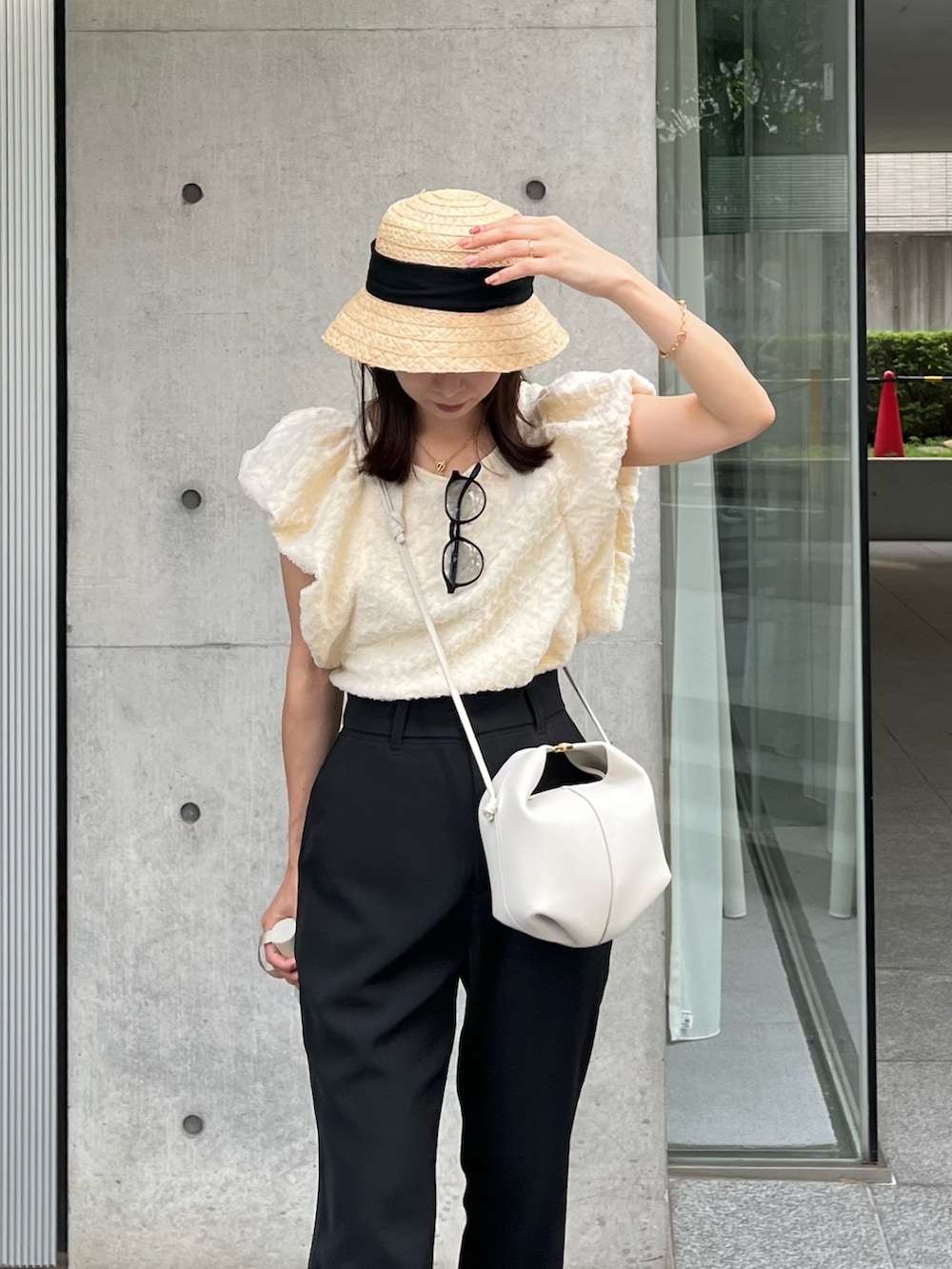 ブラック系のその他パンツ、ホワイト系のTシャツ/カットソー、ホワイト系のバッグを着用したレディースの夏コーディネートの3枚目の写真