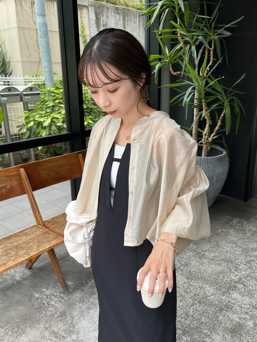 ベージュ系のシャツ/ブラウス、ブラック系のワンピース、ホワイト系のバッグを着用したレディースの夏コーディネートの4枚目の写真