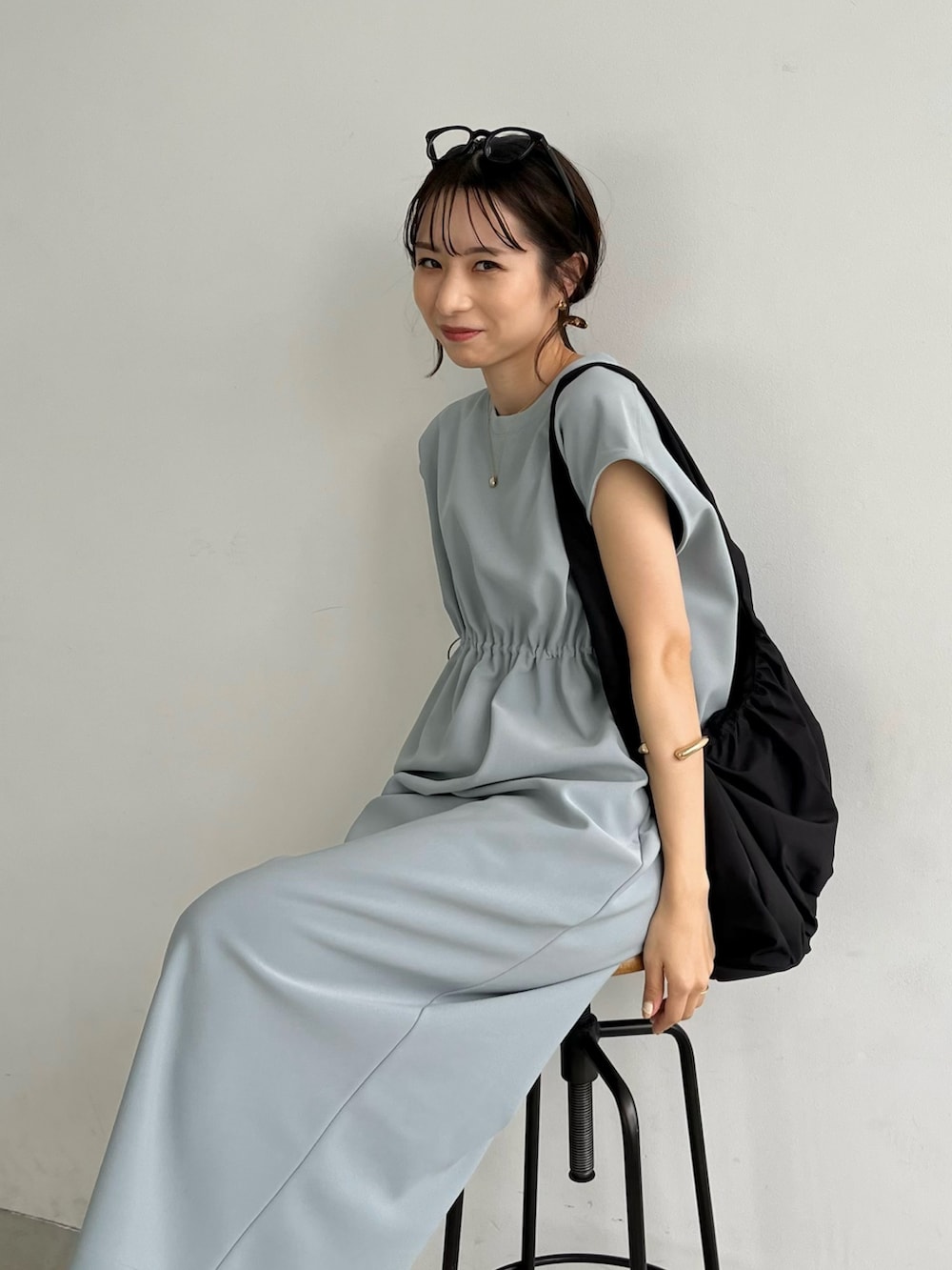 ブルー系のワンピース/ドレス、ブラック系のショルダーバッグ、ホワイト系のサンダルを着用したレディースの春コーディネートの6枚目の写真