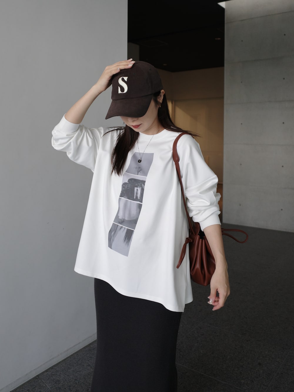 ホワイト系のTシャツ/カットソー、ブラウン系のショルダーバッグ、グレー系のスカートを着用したレディースの冬コーディネートの3枚目の写真