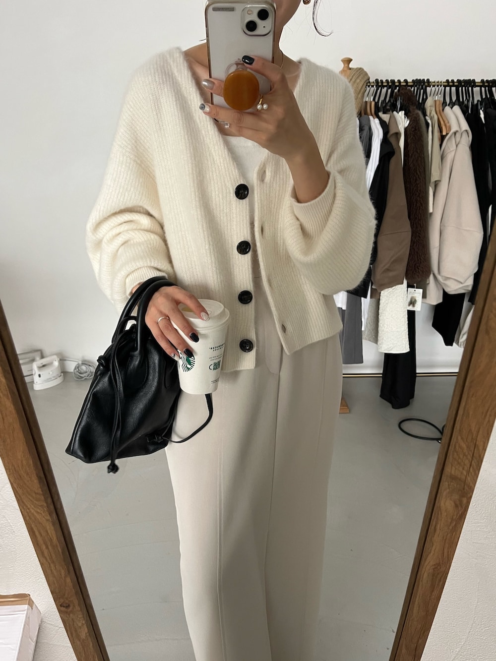 ホワイト系のカーディガン/ボレロ、ブラック系のパンプス、ホワイト系のスカートを着用したレディースの秋コーディネートの3枚目の写真