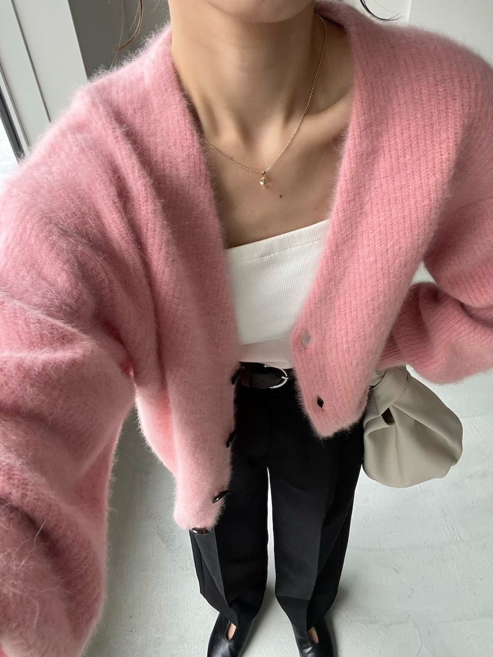 ブラック系のスラックス、ピンク系のカーディガン/ボレロ、ホワイト系のタンクトップを着用したレディースの夏コーディネートの4枚目の写真