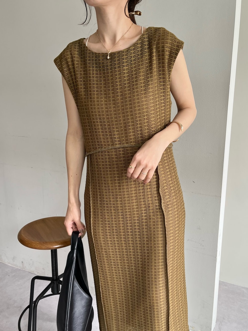 ベージュ系のワンピース、ブラック系のバッグ、ブラック系のサンダルを着用したレディースの春コーディネートの5枚目の写真