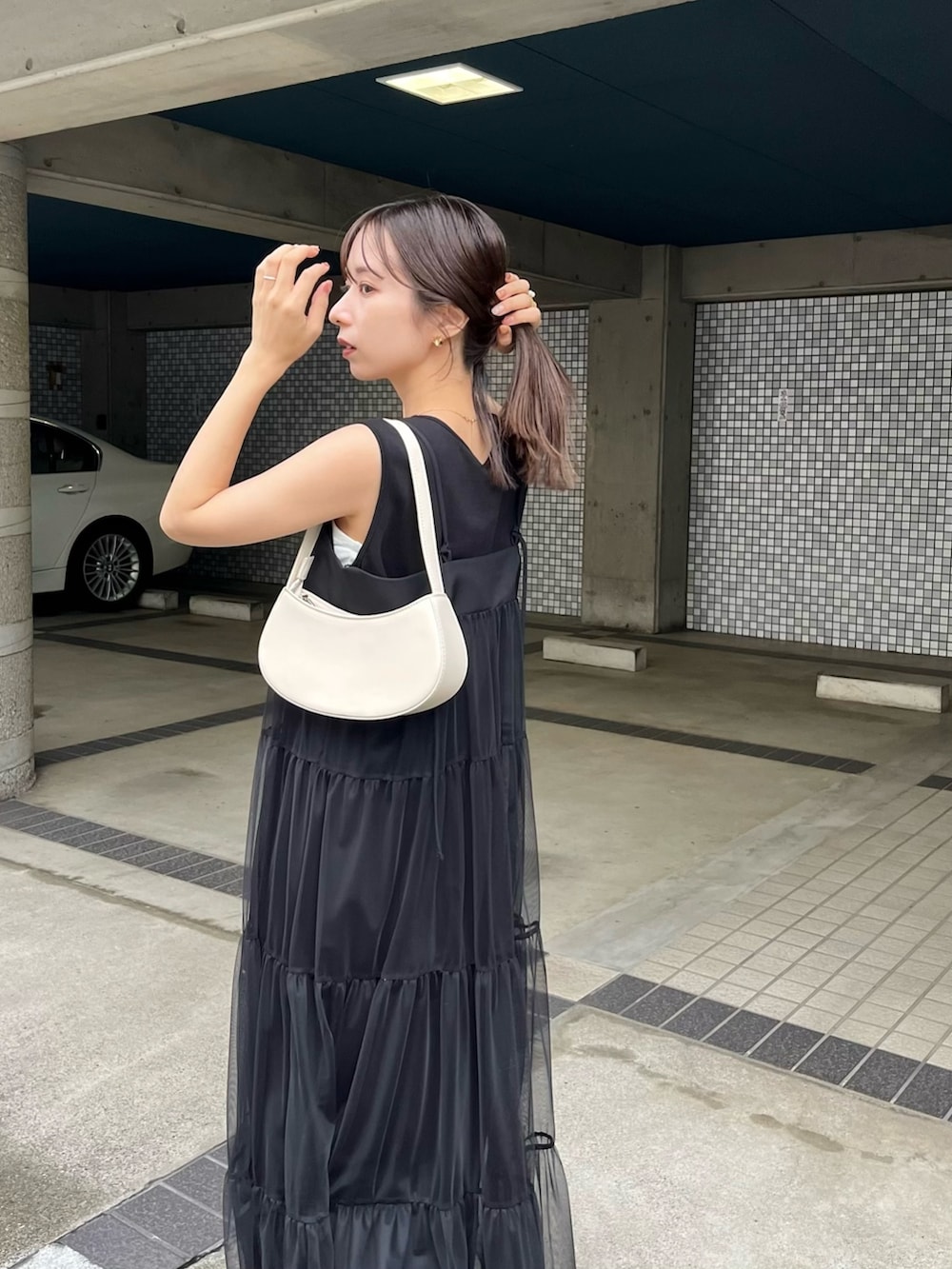 ブラック系のワンピース、ブラック系のその他シューズ、ホワイト系のショルダーバッグを着用したレディースの夏コーディネートの5枚目の写真