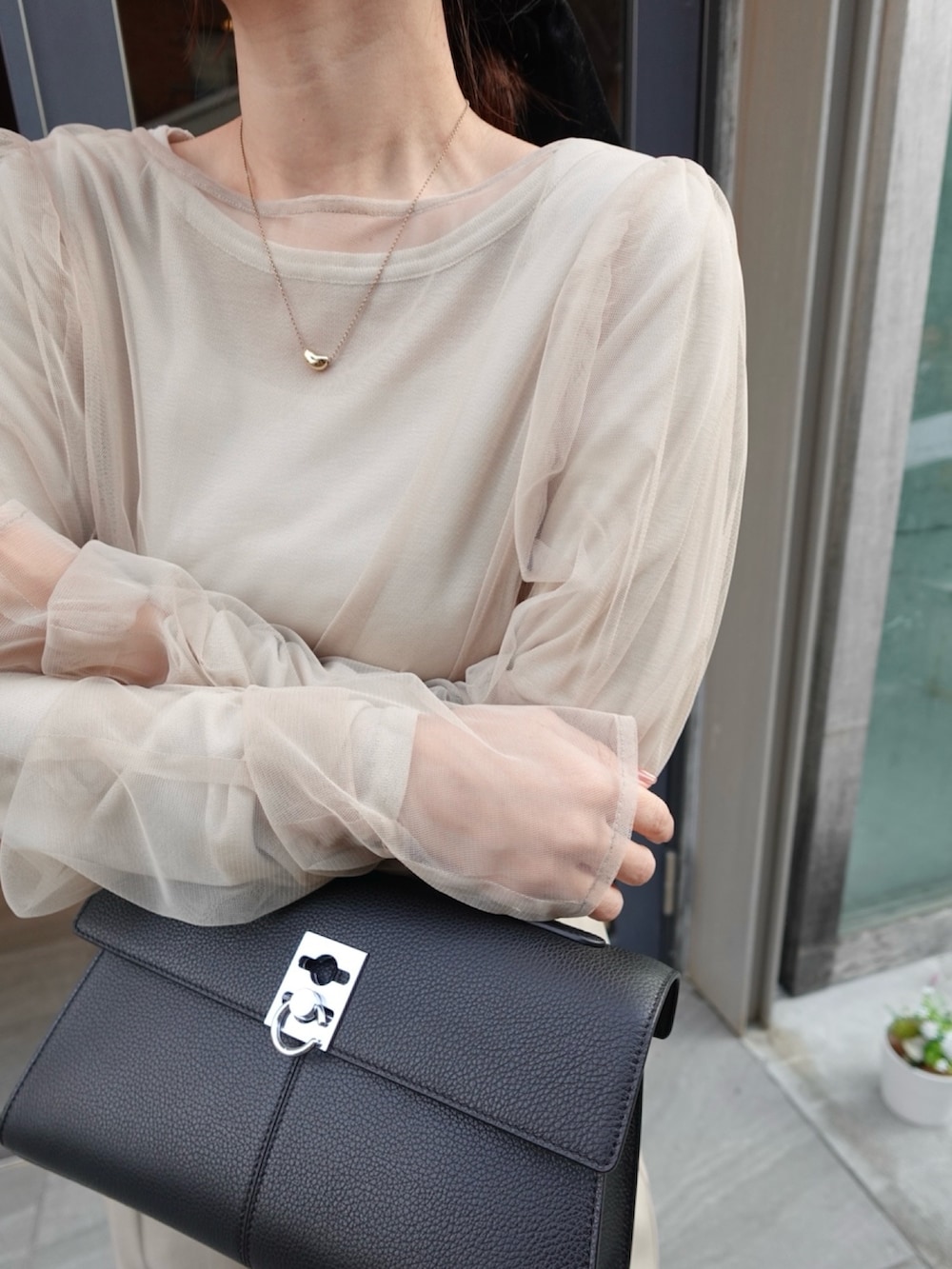 ベージュ系のTシャツ/カットソー、ベージュ系のその他パンツ、ブラック系のハンドバッグを着用したレディースの春コーディネートの4枚目の写真