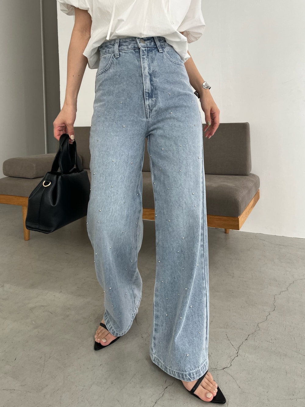 ブルー系のデニムパンツ、ホワイト系のシャツ/ブラウス、ブラック系のショルダーバッグを着用したレディースの春コーディネートの5枚目の写真