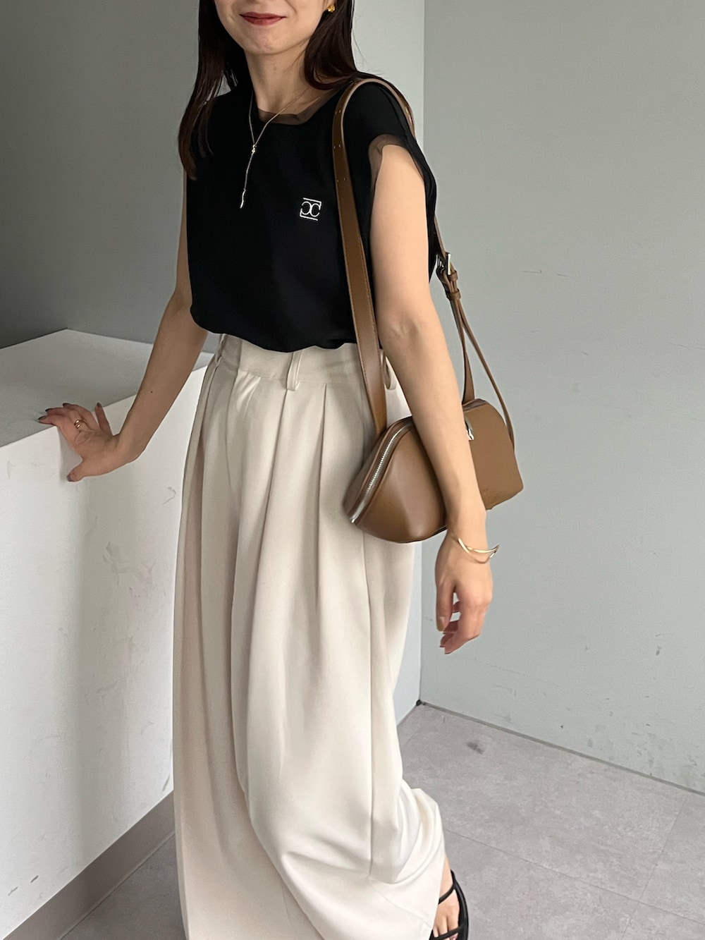 ホワイト系のその他パンツ、ブラック系のTシャツ/カットソー、ブラック系のサンダルを着用したレディースの夏コーディネートの2枚目の写真