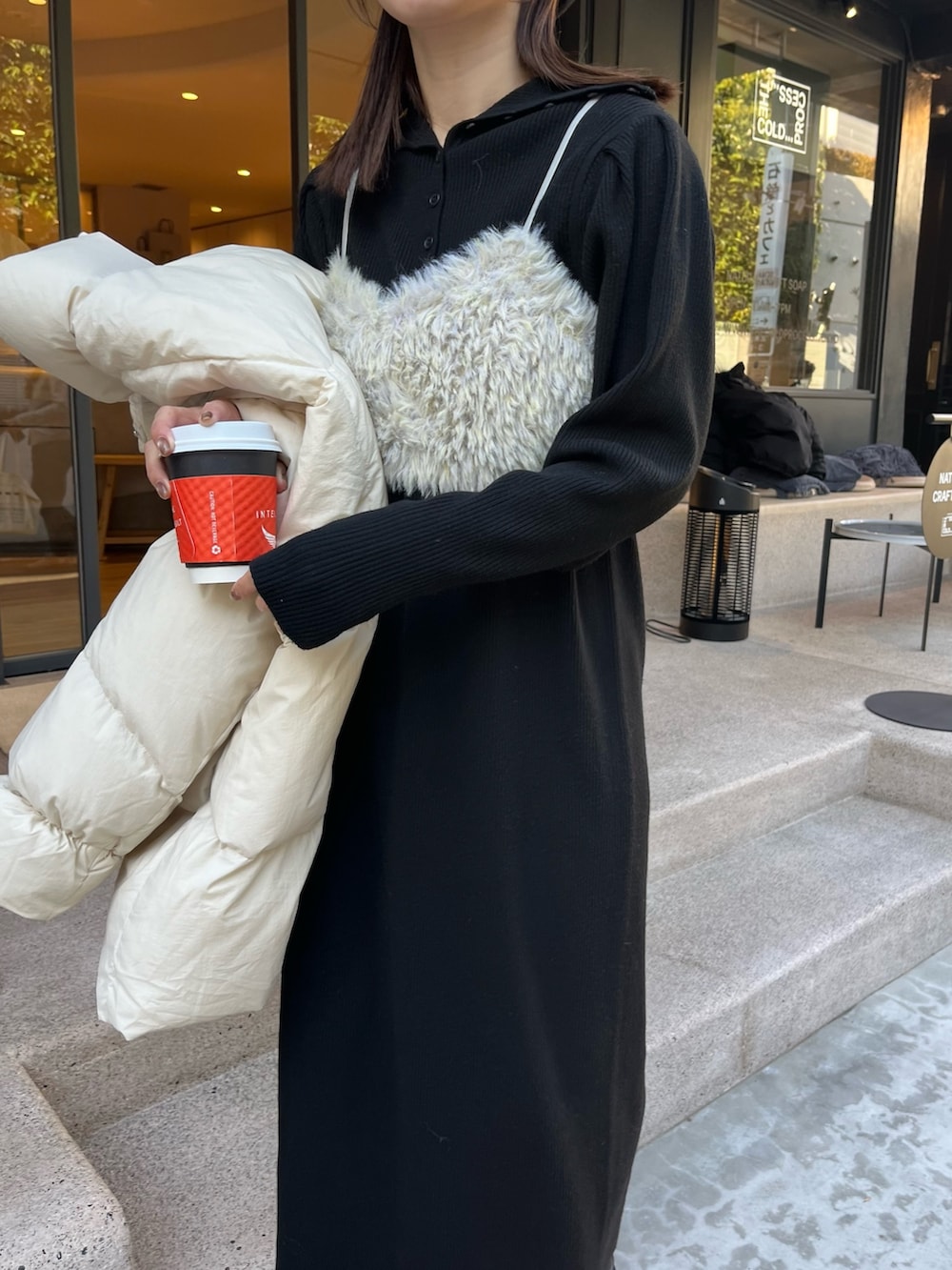 ブラック系のワンピース、ホワイト系のダウンジャケット/コート、グリーン系のトップスを着用したレディースの冬コーディネートの7枚目の写真