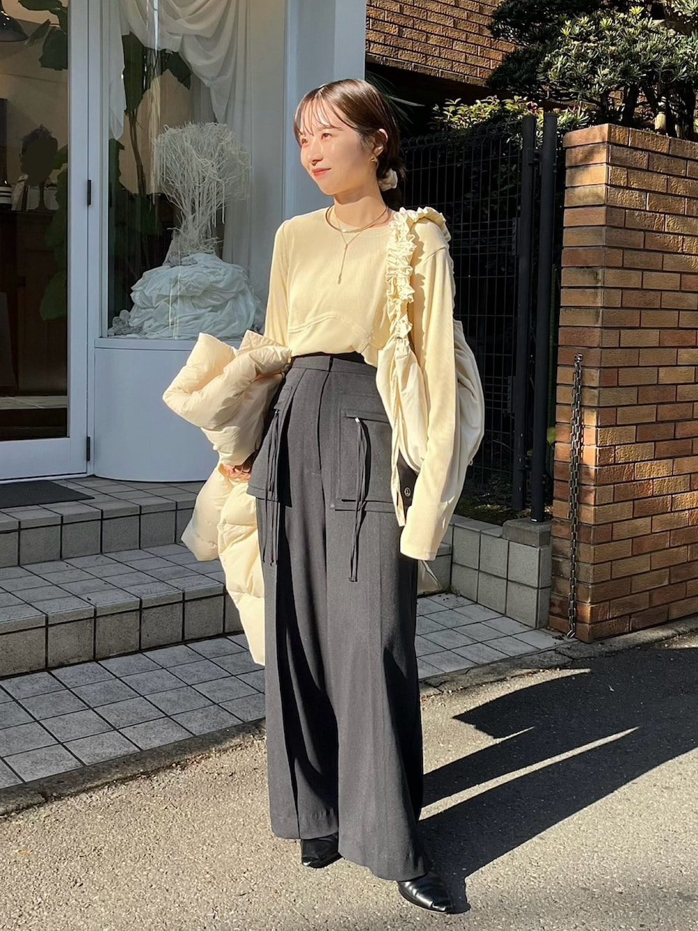 ブラック系のその他パンツ、ブラック系のパンプス、ベージュ系のTシャツ/カットソーを着用したレディースの冬コーディネートの2枚目の写真