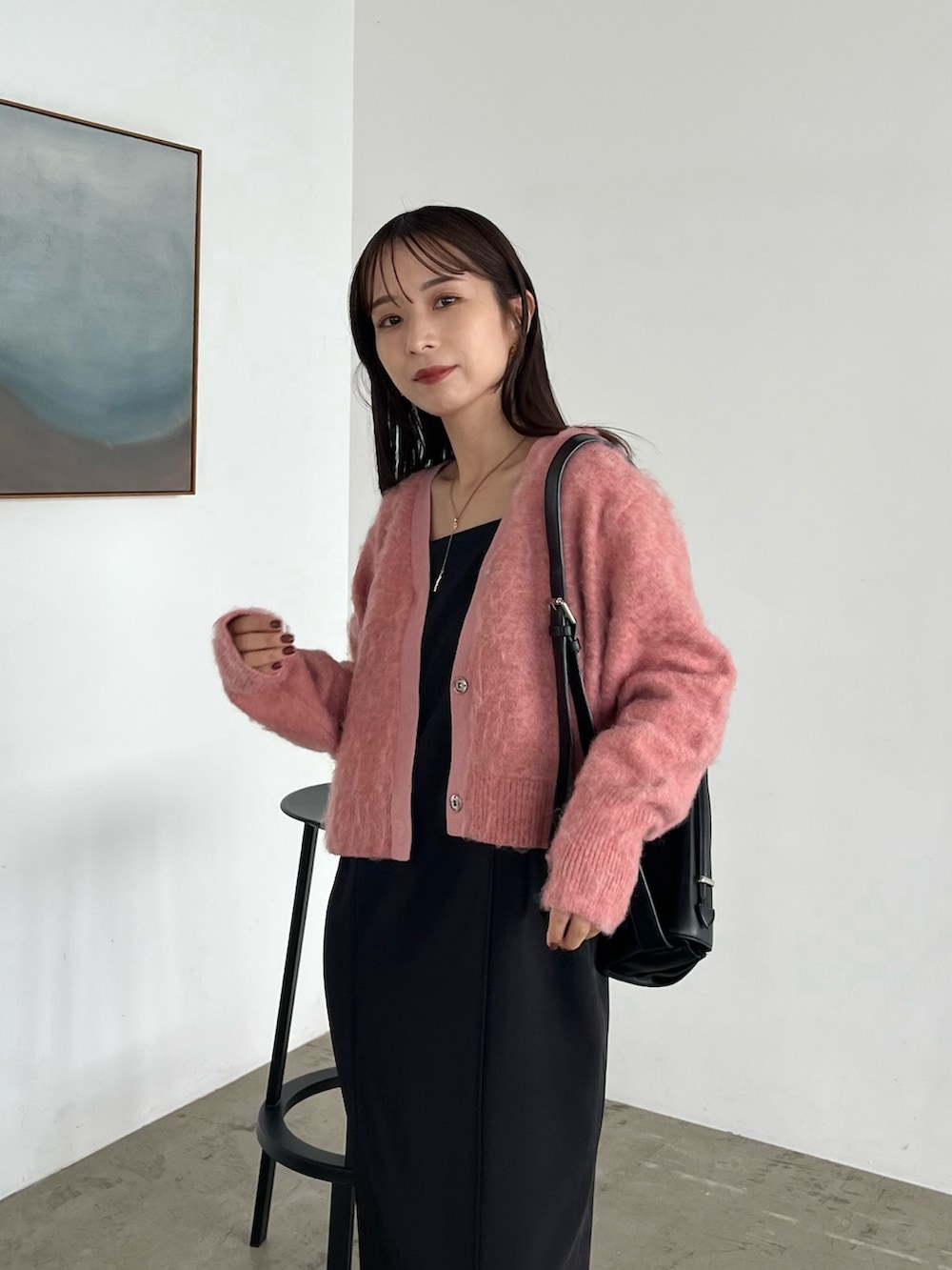 ブラック系のワンピース、ブラック系のパンプス、ブラック系のショルダーバッグを着用したレディースの秋コーディネートの5枚目の写真