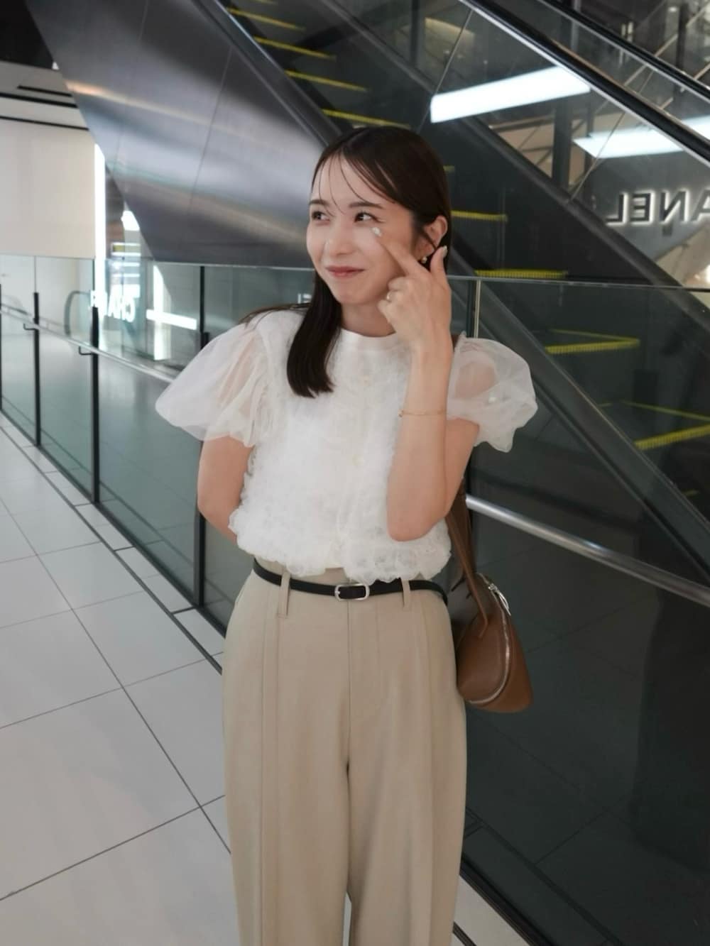 イエロー系のショルダーバッグ、ベージュ系のその他パンツ、ホワイト系のTシャツ/カットソーを着用したレディースの夏コーディネートの2枚目の写真