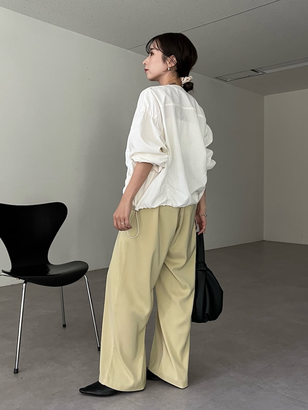 ブラック系のハンドバッグ、グリーン系のその他パンツ、ホワイト系のキャミソールを着用したレディースの春コーディネートの4枚目の写真