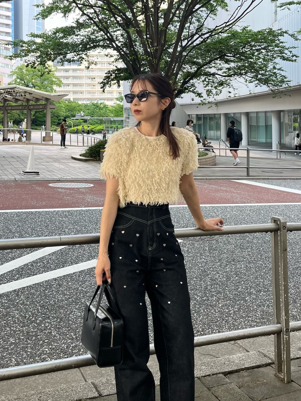 ブラック系のデニムパンツ、ホワイト系のTシャツ/カットソー、ブラック系のバレエシューズを着用したレディースの夏コーディネートの3枚目の写真