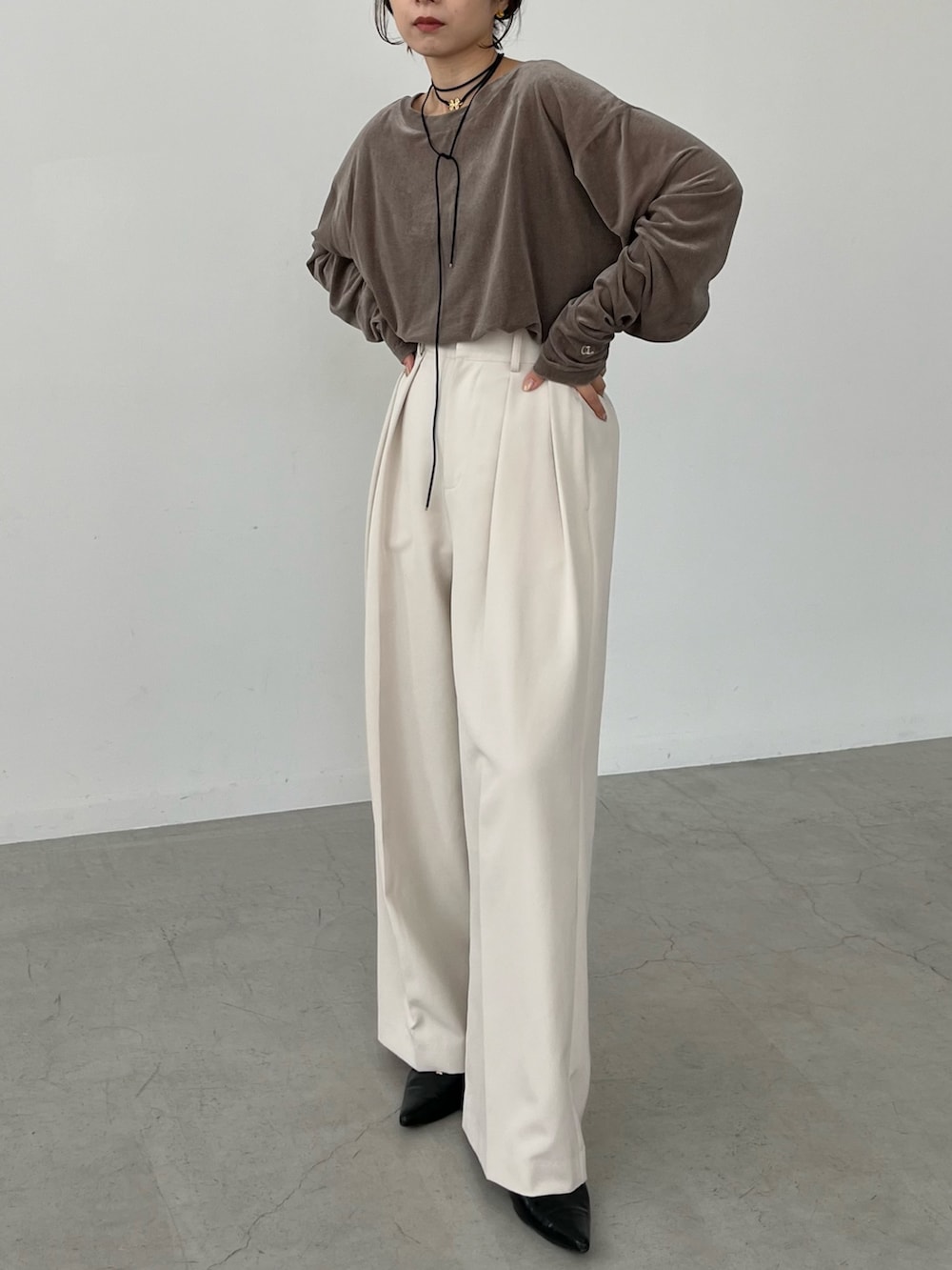 ホワイト系のその他パンツ、ベージュ系のTシャツ/カットソー、ブラック系のパンプスを着用したレディースの秋コーディネートの2枚目の写真