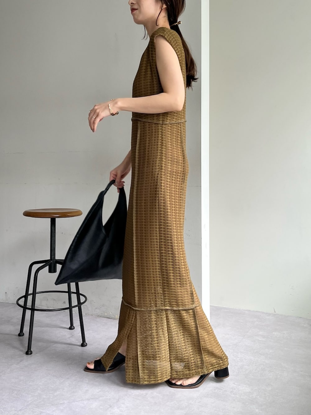 ベージュ系のワンピース、ブラック系のバッグ、ブラック系のサンダルを着用したレディースの春コーディネートの4枚目の写真