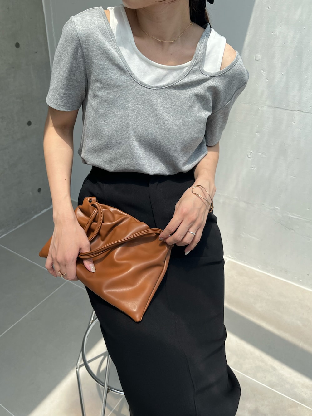 ブラック系のスカート、グレー系のTシャツ/カットソー、ブラック系のサンダルを着用したレディースの夏コーディネートの4枚目の写真